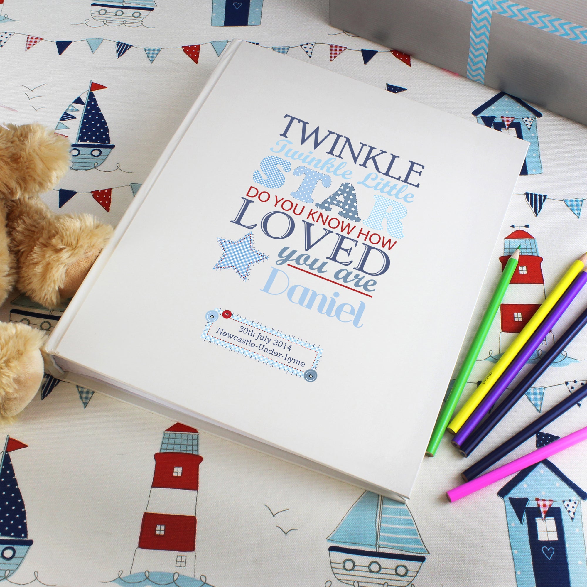 Personalised photo album with the text 'twinkle twinkle little star do you know how loved you are' printed on the front cover in various fonts and sizes in different shades of blue and red. The cover can be personalised with a name and message or celebration details of your choice. Internally the album has approximately 30 pages interleafed with tissue.